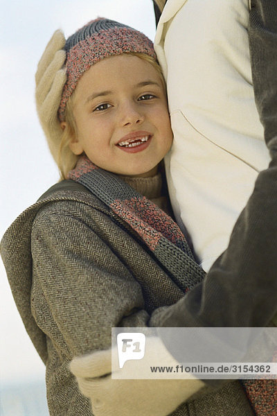 Kleines Mädchen umarmt Elternteil  Portrait