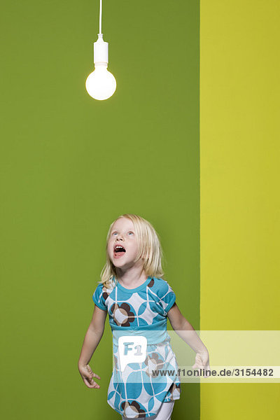 Kleines Mädchen schreit nach einer beleuchteten Glühbirne