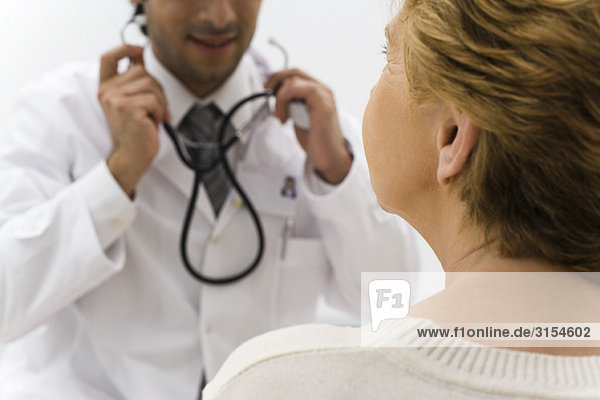 Arzt bereitet sich auf die Untersuchung des Patienten mit dem Stethoskop vor