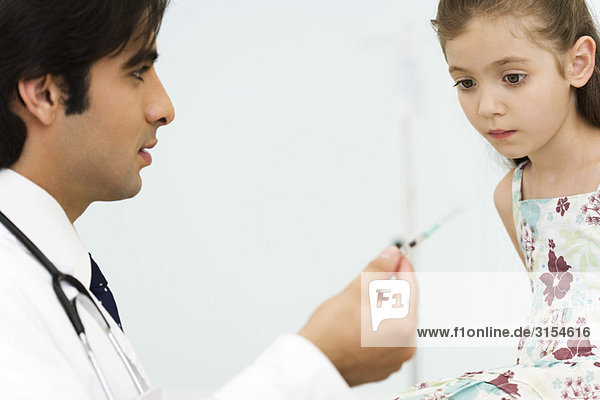 Kinderarzt zeigt kleine Mädchenspritze