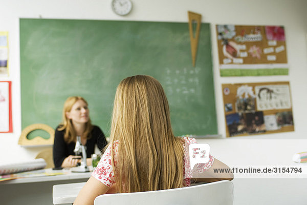 Mädchen sitzt aufmerksam im Klassenzimmer der Grundschule