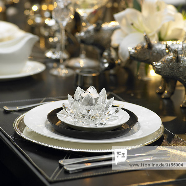 Table setting with dinner plate and crystal votive candle holder