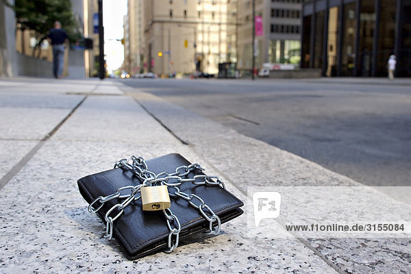 Lost wallet wrapped in chains and locked on sidewalk