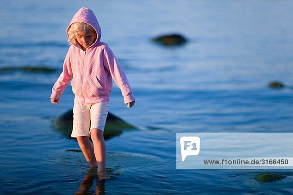 Ein kleines Mädchen im blauen Wasser Schweden.