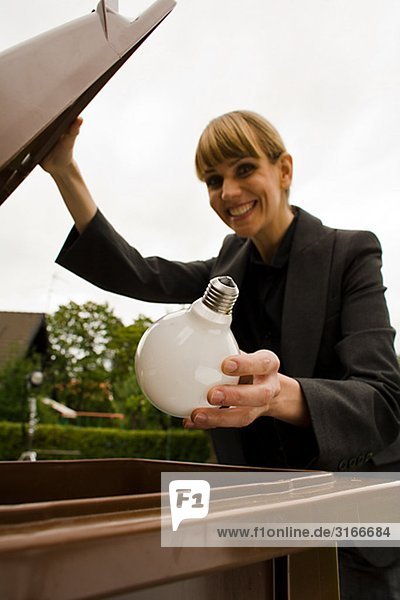 Eine Frau recycling einer Glühbirne  Schweden.