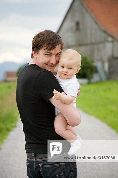 Ein Vater hält seine Baby-Schweiz.