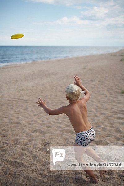 Ein Junge mit einem Frisbee Gotland Schweden spielen.