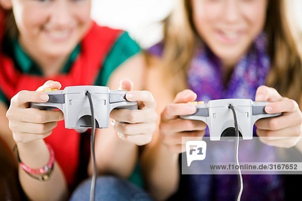Two teenage girls playing a video game.