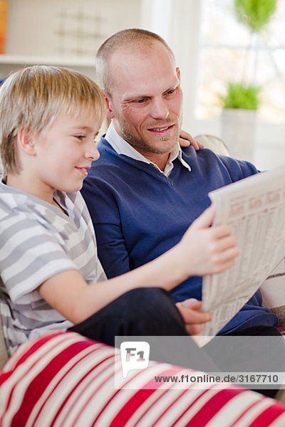 Father and son reading the newspaper  Sweden.