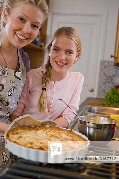 Mutter und Tochter mit einem frisch gebackenen Kuchen  Schweden.
