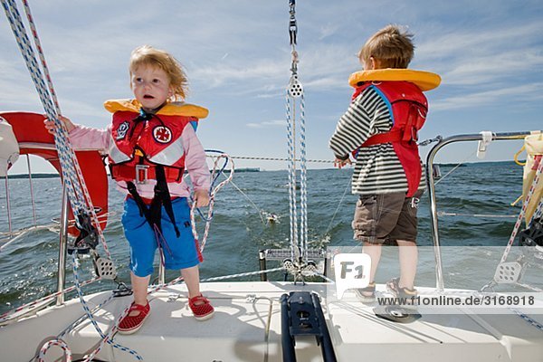 A girl and a boy standing on a sailing-boat  Sweden.