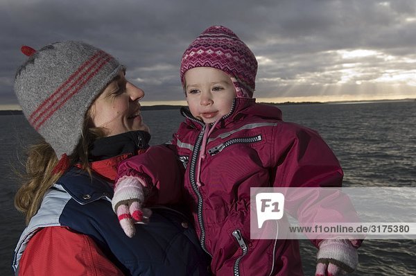 Mutter und Tochter am Meer im Winter  Schweden.