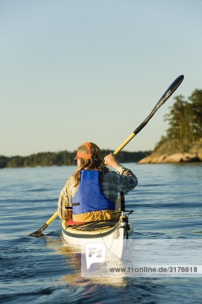 A woman canoing  Stockholm archipelago  Sweden.