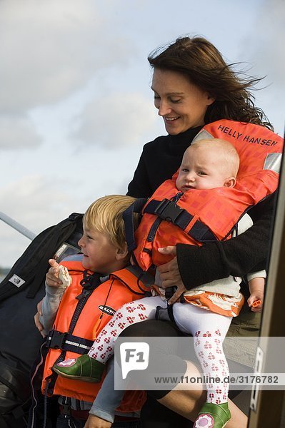 A woman with children who are wearing life jackets  Sweden.
