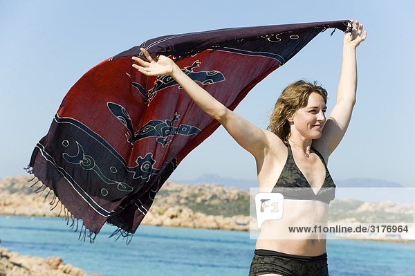 A woman enjoying the sun and the wind  Sardinia  Italy.