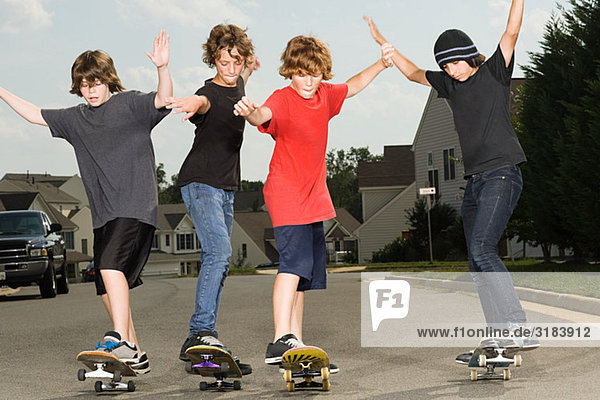 Vier Jungs beim Skateboarden