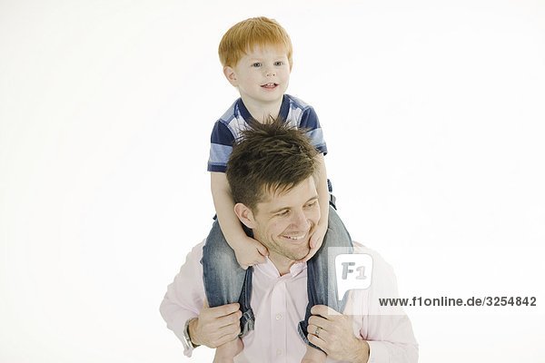 Father carrying his son on the shoulders.