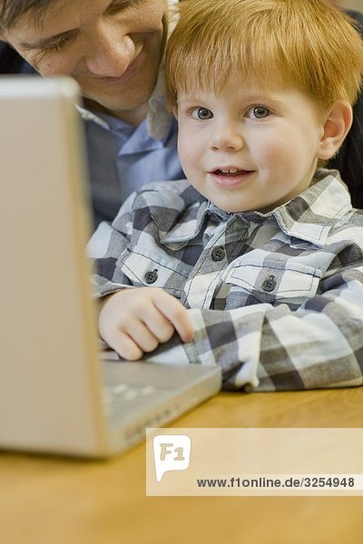 Vater und Sohn mit einem Laptop  Schweden.