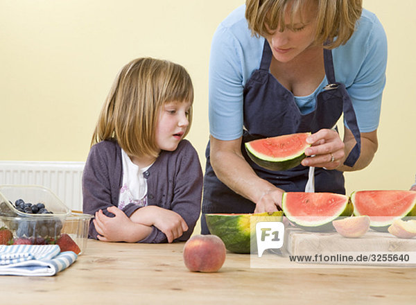 Mädchen und Mutter mit Wassermelonenscheiben