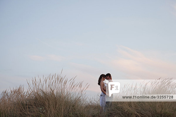 couple kissing in the reed at the beach