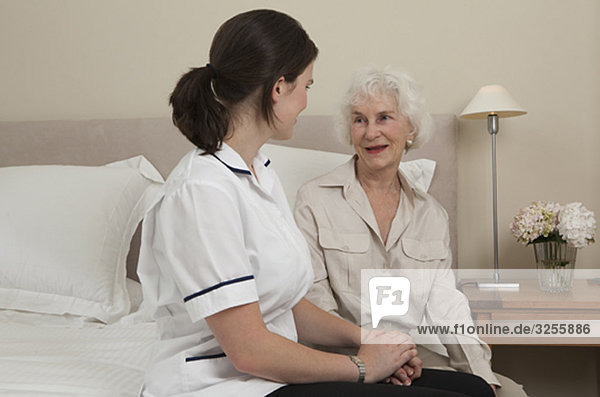 Krankenschwester hält Hand der älteren Frau