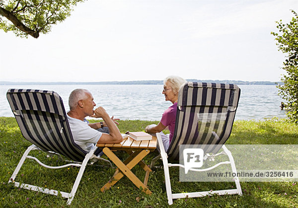 senior man and woman in deck chairs
