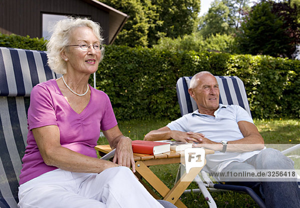 senior man and woman in deck chairs