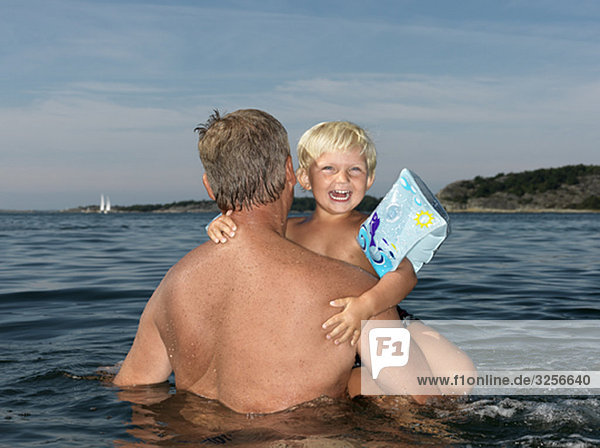 Großvater und Junge spielen im Wasser