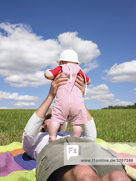 father and baby in field