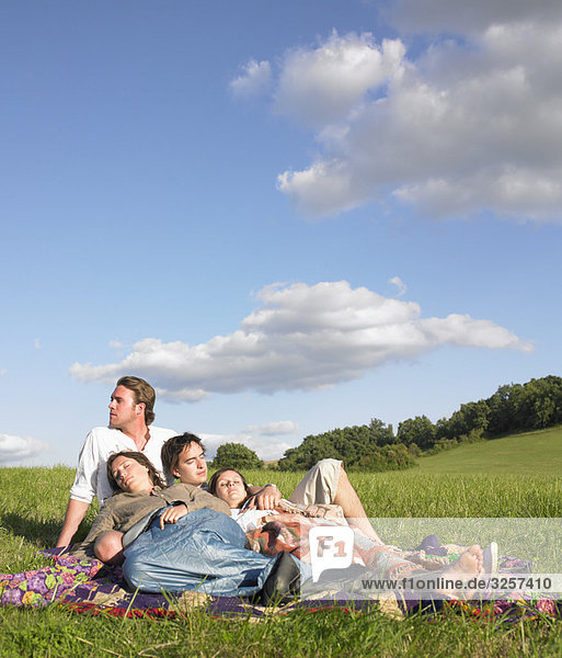 young people lying in field