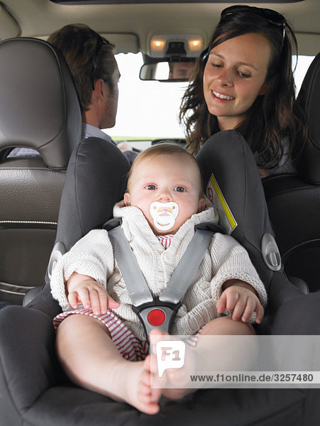 Mutter beobachtet Baby im Autositz