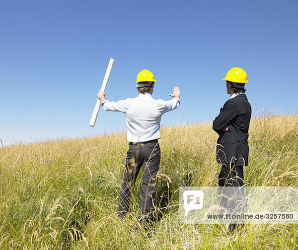 contractors with blueprints in field