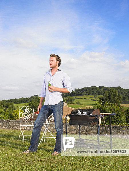 man tending barbecue in front of view