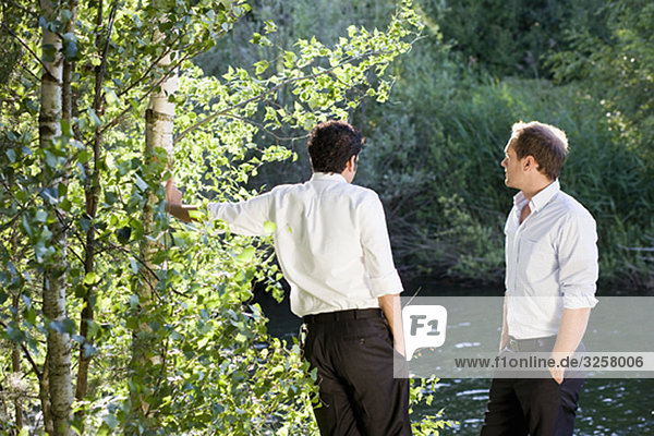 two businessmen talking on lakefront