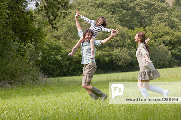 Family running in country field