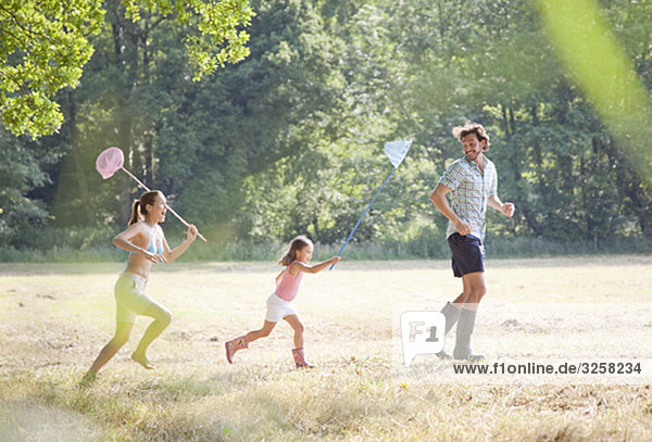 Family in countryside running with nets