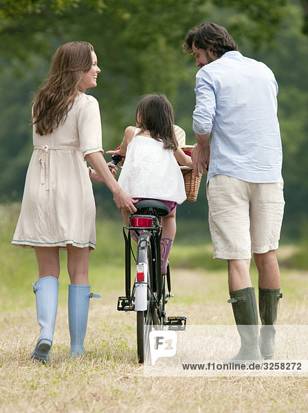 Family walking in country with bike