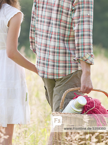 couple in hats walking through meadow