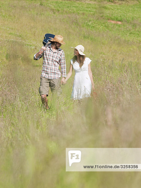 couple walking through long grass