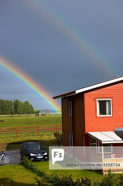 Rainbow over houses  Sweden.