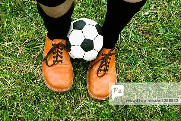 A football between two feet.