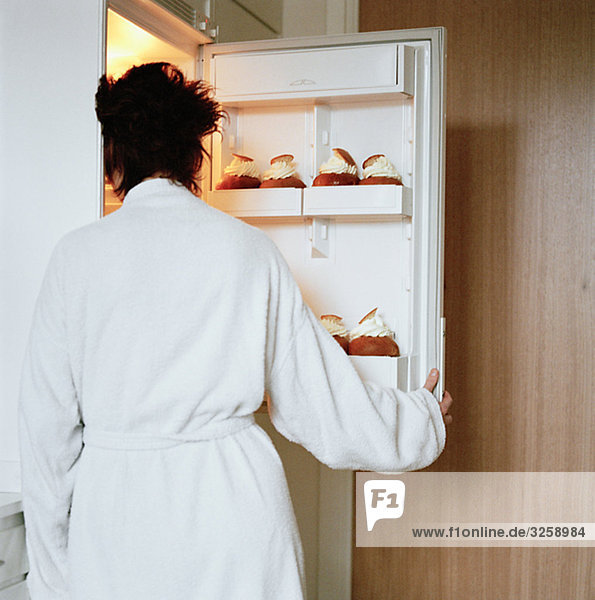 A woman opening a refrigerator