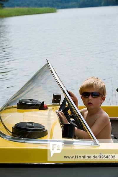 A boy driving a boat  Smaland  Sweden.