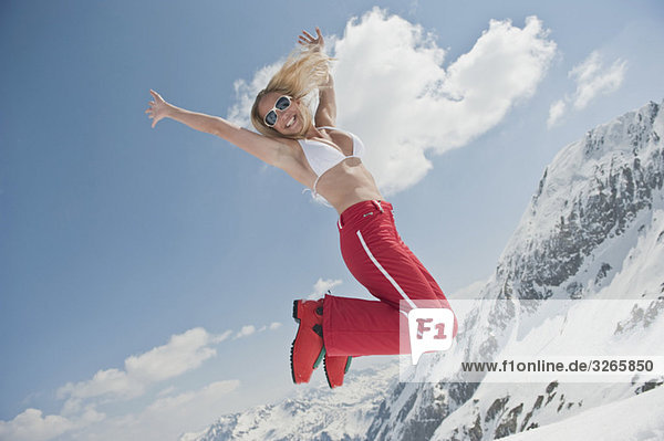 Austria  Salzburger Land  Young woman jumping in air