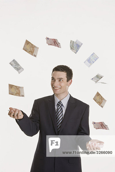 Businessman juggling Euro notes