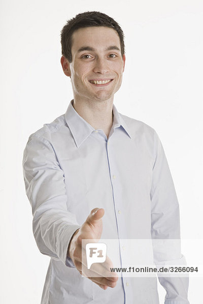 Businessman putting forth his his hand  smiling  portrait