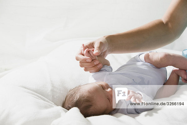 Vater hält Baby-Mädchen (0-4 Wochen) Hand