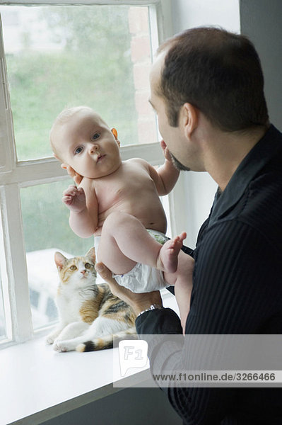 Vater durch das Fenster hält Baby Junge (6-11 Monate)
