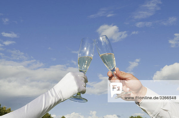 Germany  Bavaria  Couple toasting with champagne glasses  close-up of hands