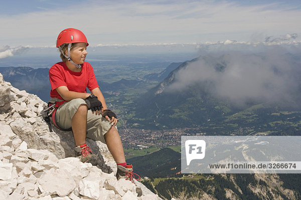 Mountaineer  Boy (12-13) sitting on summit  portrait